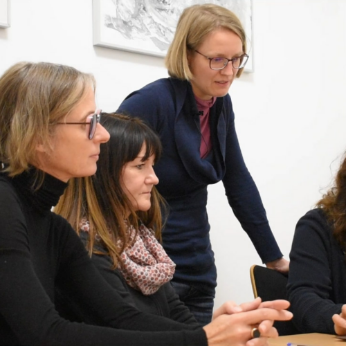 Das Foto zeigt vier Frauen auf einer digitalen Schulung des Zukunftszentrum Berlin. Sie beugen sich interessiert über einen Laptop.