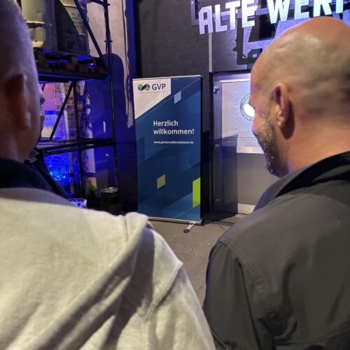 Blick auf Bühne über die Schultern zweier Besucher