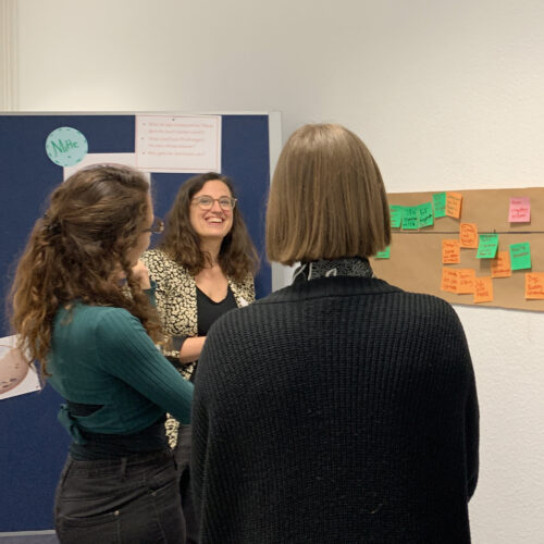 Mehrere Frauen im Gespräch über die Ergebnisse eines Workshops.